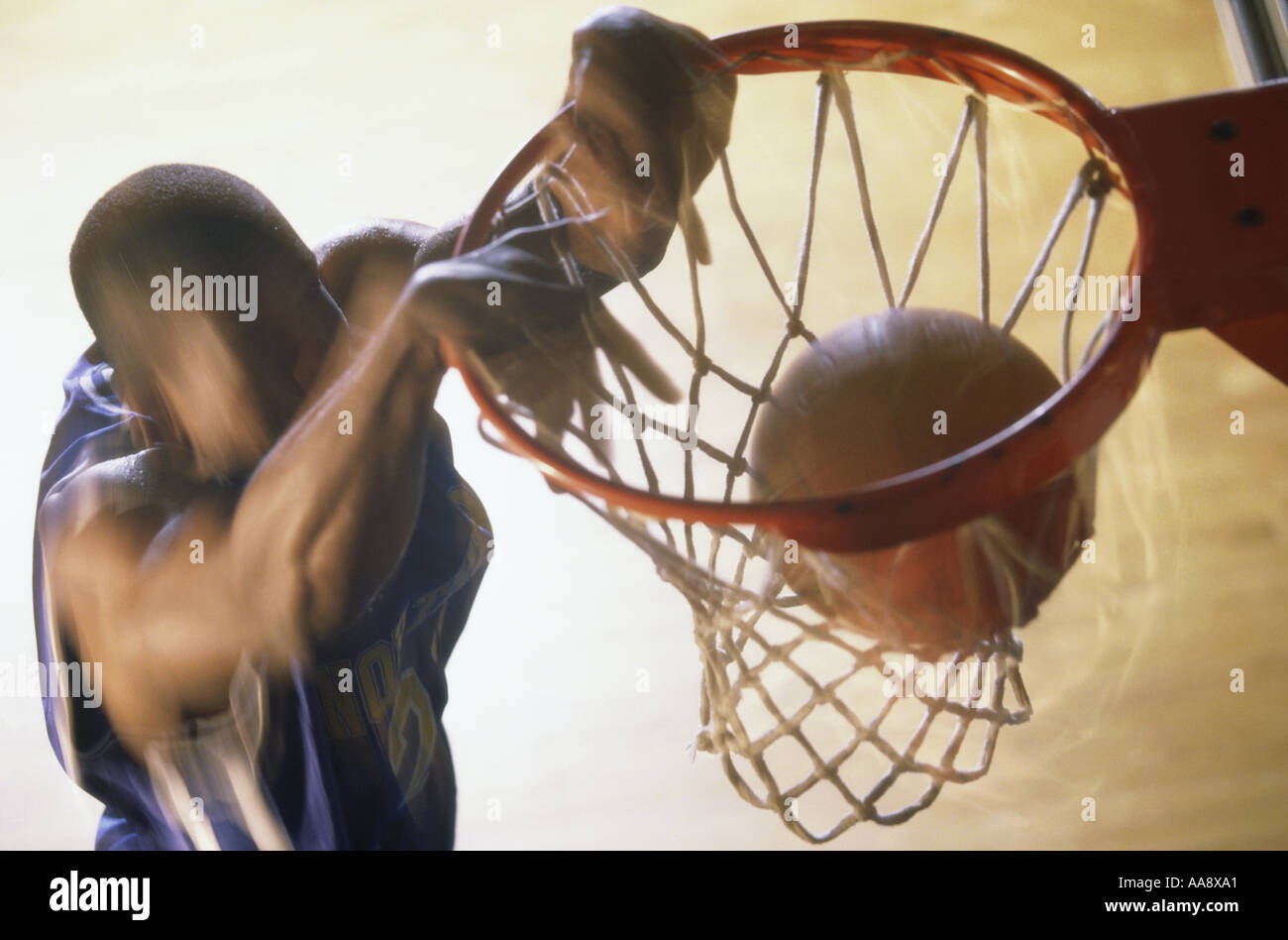 Basketball player slam dunking a ball Stock Photo