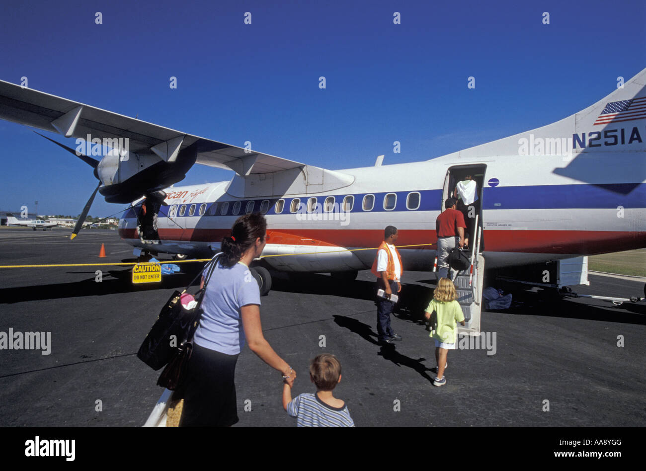 American Eagle commuter plane loading passengers single parent with children Stock Photo