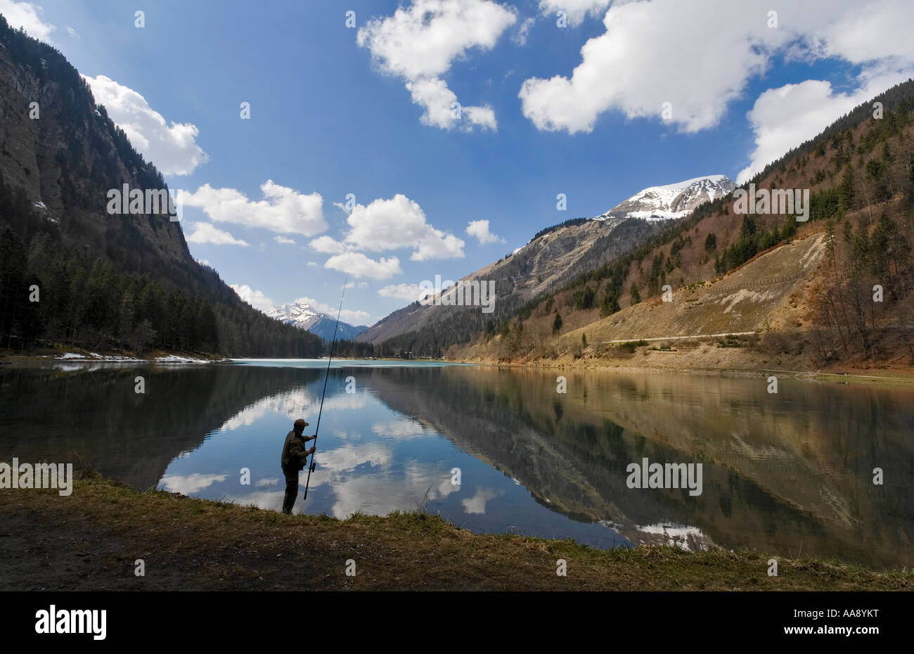 Lone fisherman at an Alpine lake - Lac de Montriond Stock Photo