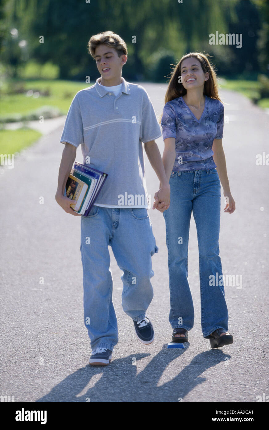 Teenage couple holding hands walking outdoors Stock Photo - Alamy