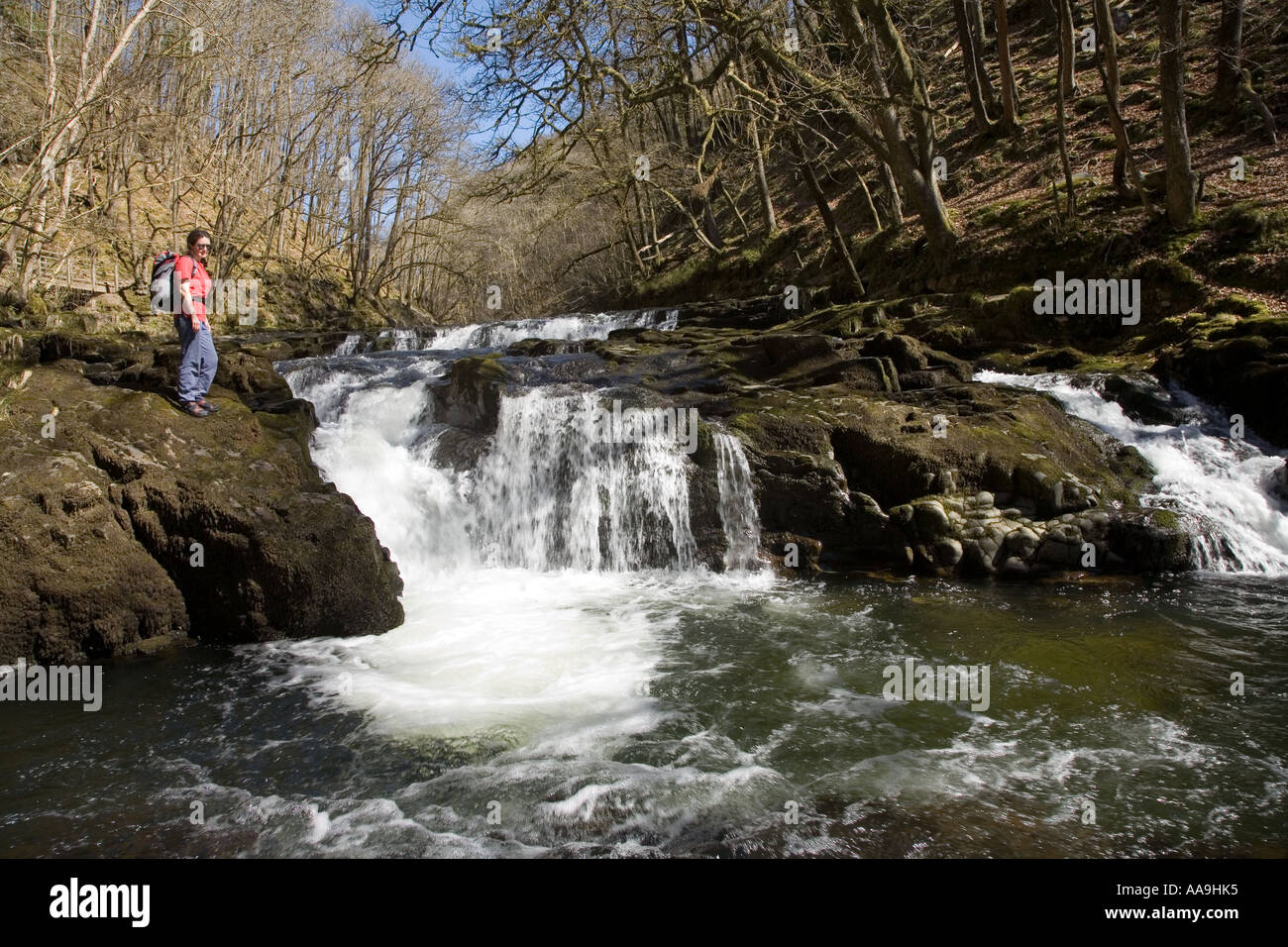 Female walker at cascades at Horseshoe Falls Afon Nedd Fechan