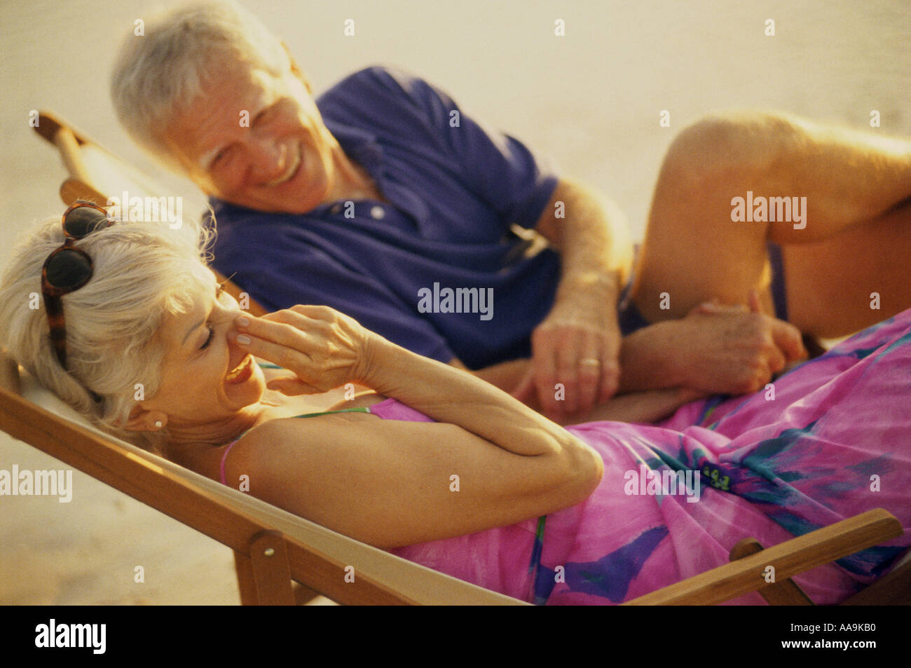 Senior couple sitting on beach chairs Stock Photo - Alamy