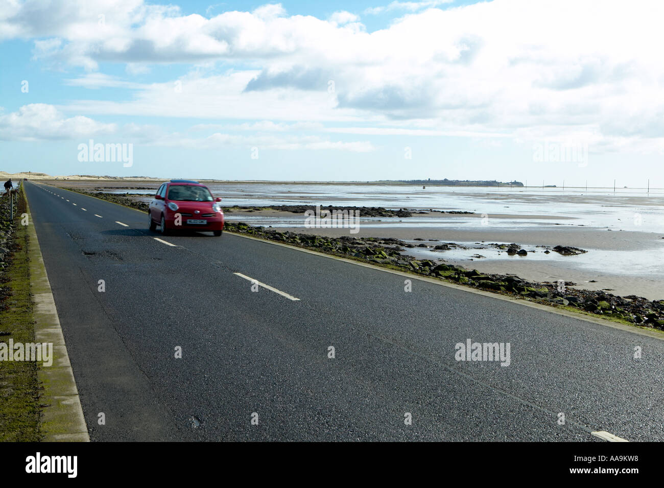 Car on causeway at Holy Island of Lindisfarne, Northumberland Stock Photo