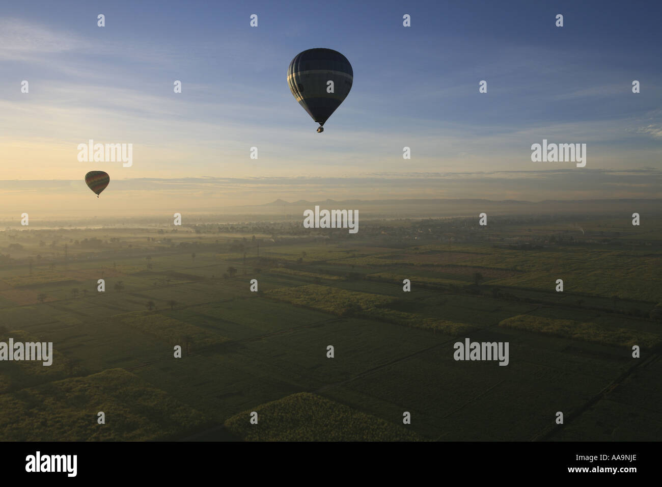 Hot Air Ballooning over fields, villages and ancient monuments in Egypt. Stock Photo