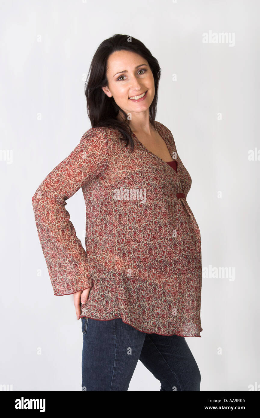 Pregnant Woman Wearing a Brown Patterned Smock Top and Jeans Stock Photo