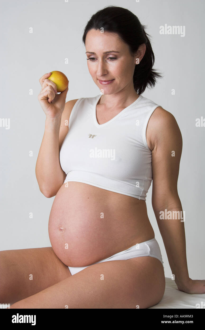 Pregnant Woman Eating an Apple Stock Photo