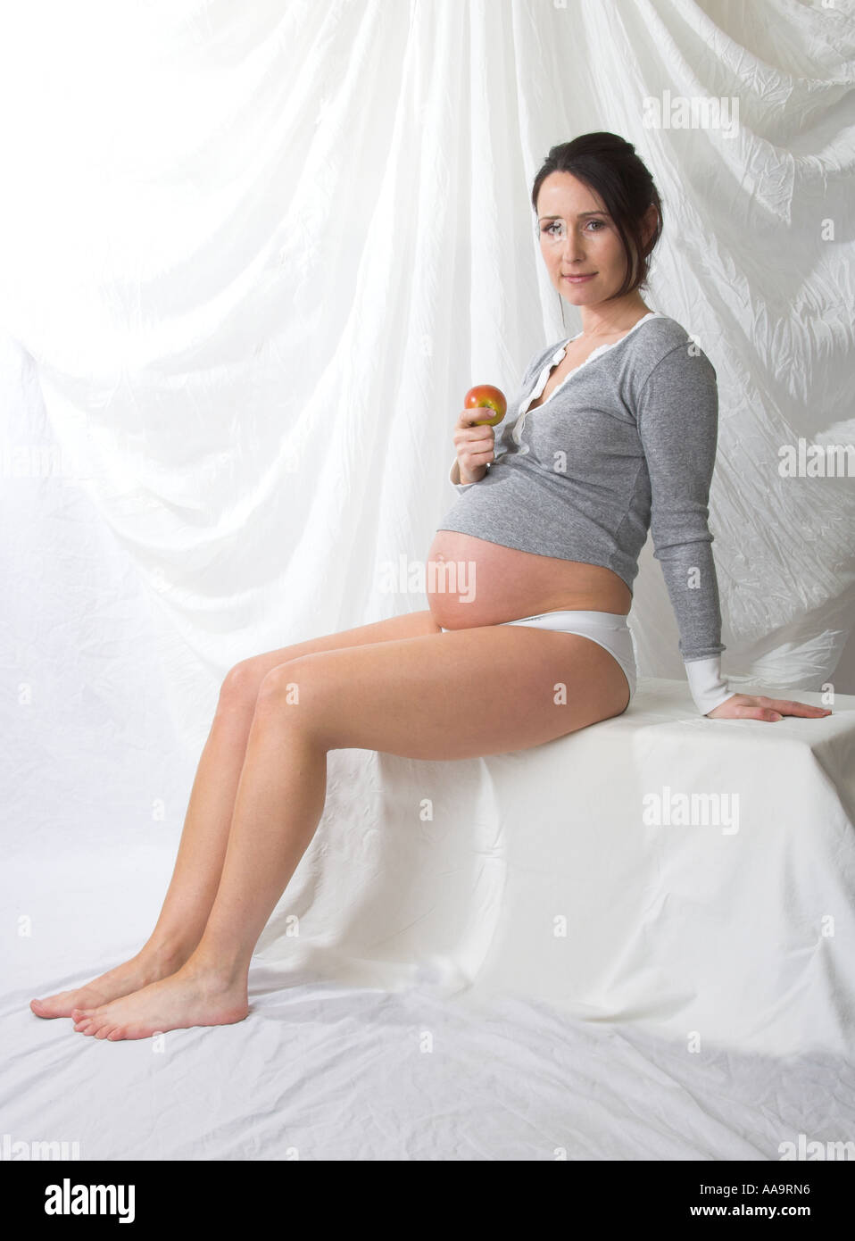 Pregnant Woman Sitting Eating an Apple Stock Photo