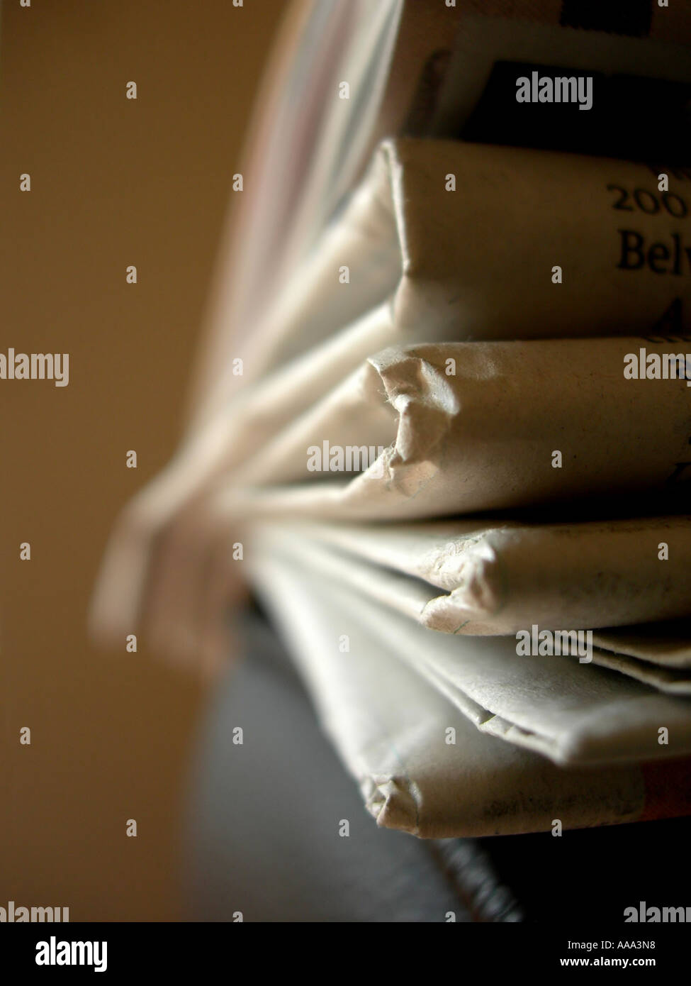 Many sections of a saturday edition newspaper on the arm of a chair Stock Photo