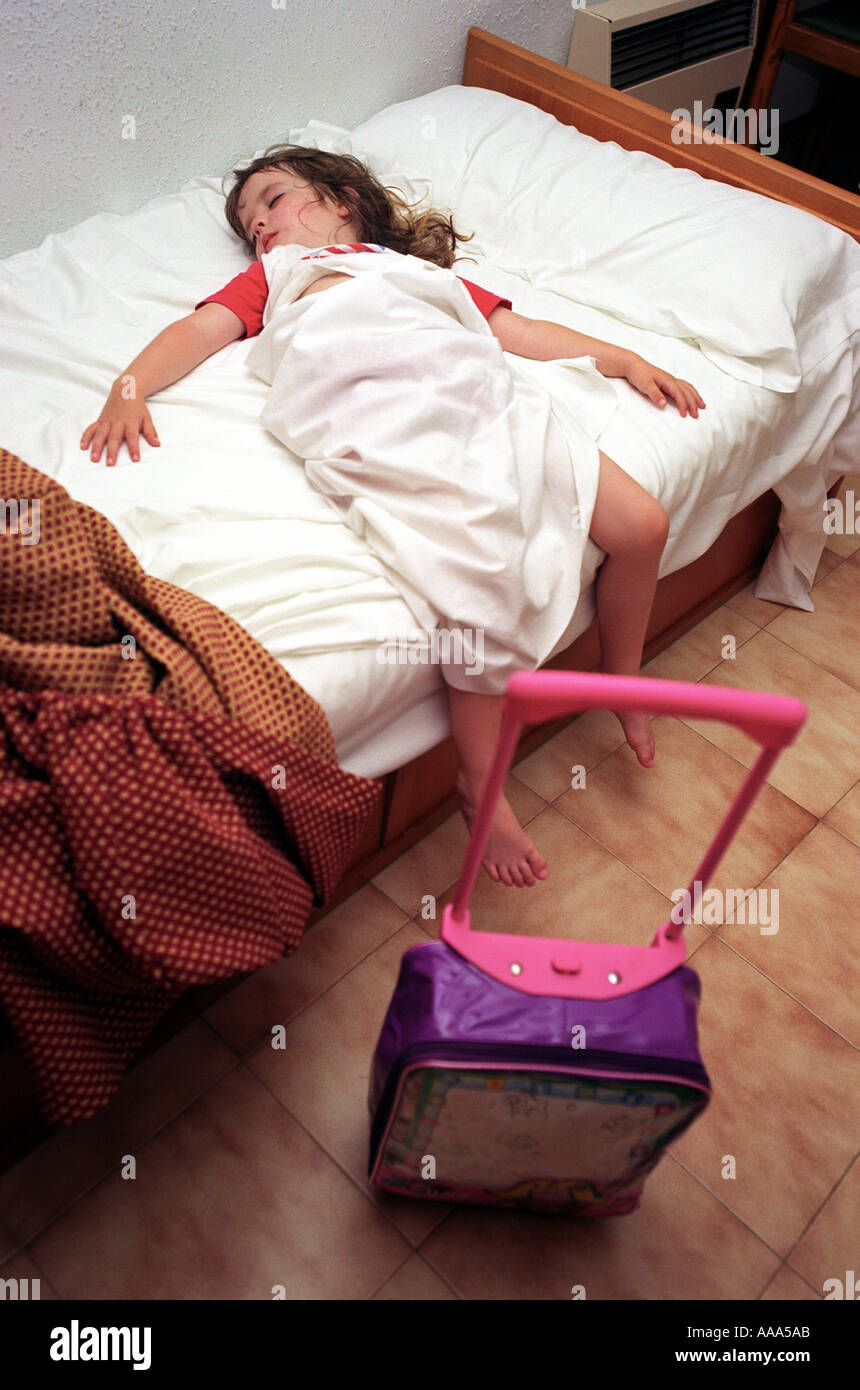 A child asleep with travel bag after a long journey Stock Photo