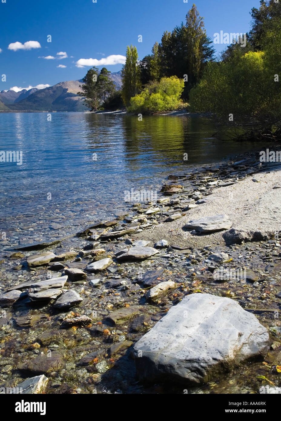 The rocky bank of lake Wakatipu on a sunny, summer's day, South island ...