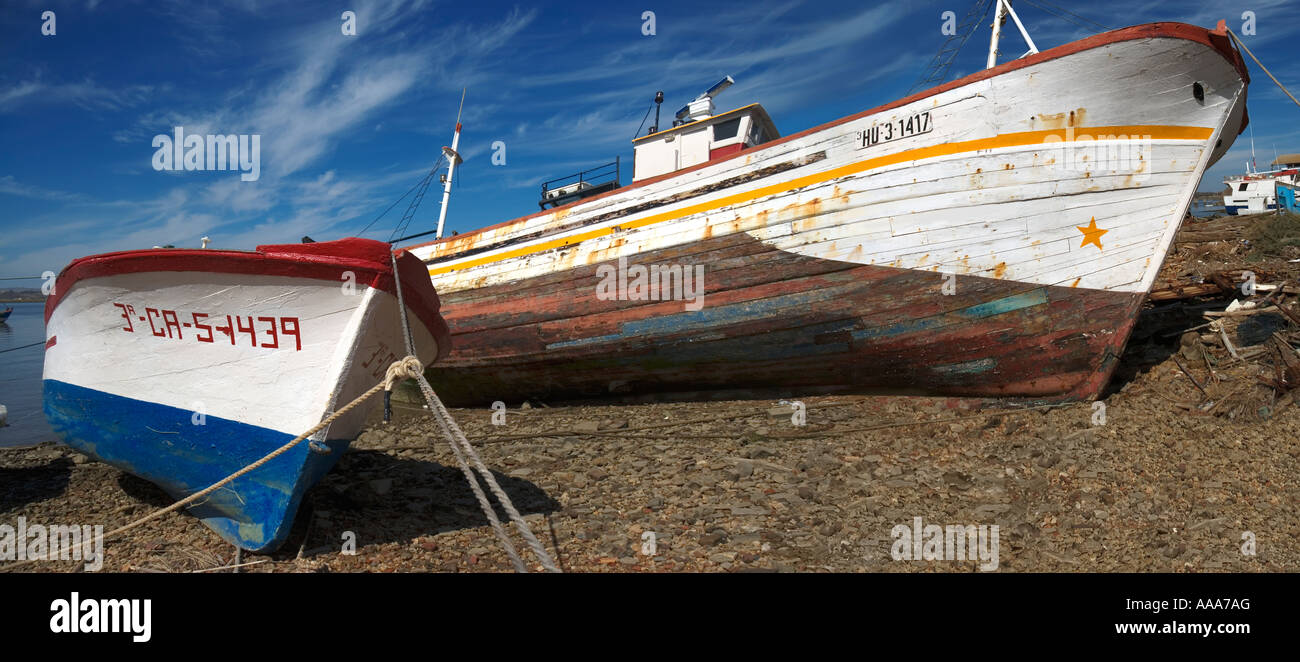 Two wooden fishing boats tied up aground on the banks of the River Guadiana in Ayamonte Spain Stock Photo