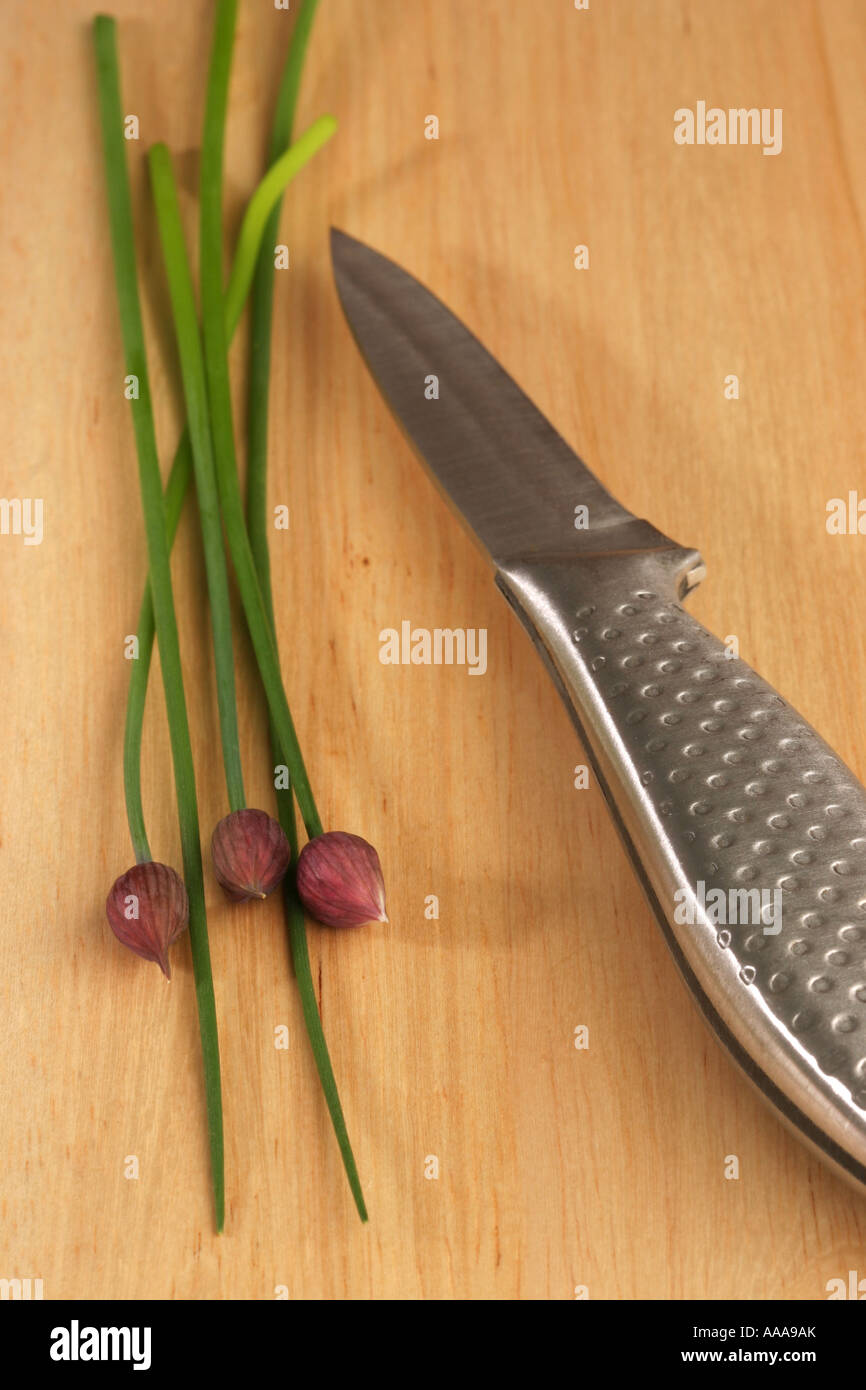 Fresh Chives on a chopping board with a knife Stock Photo