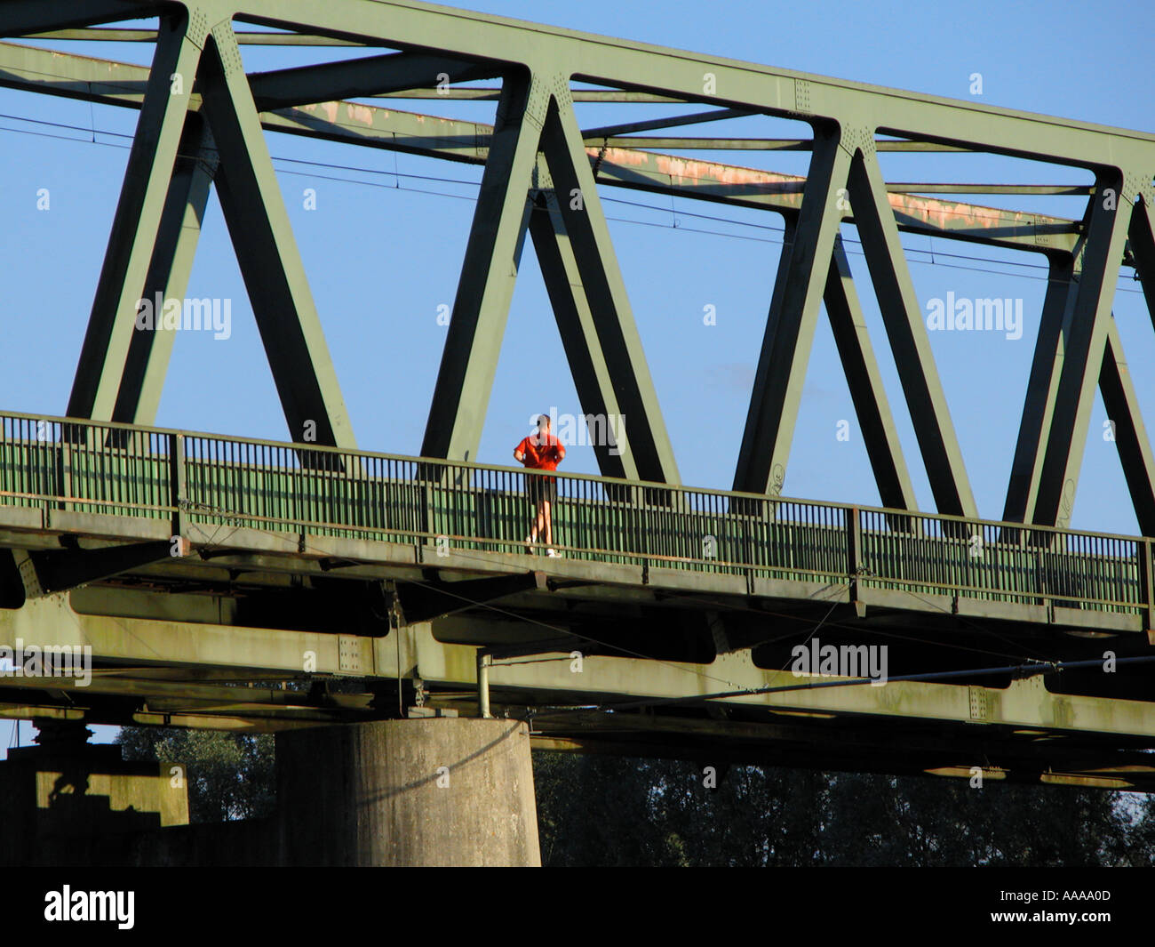 the red dressed jogger on the rail bridge man jogging exercise Stock ...