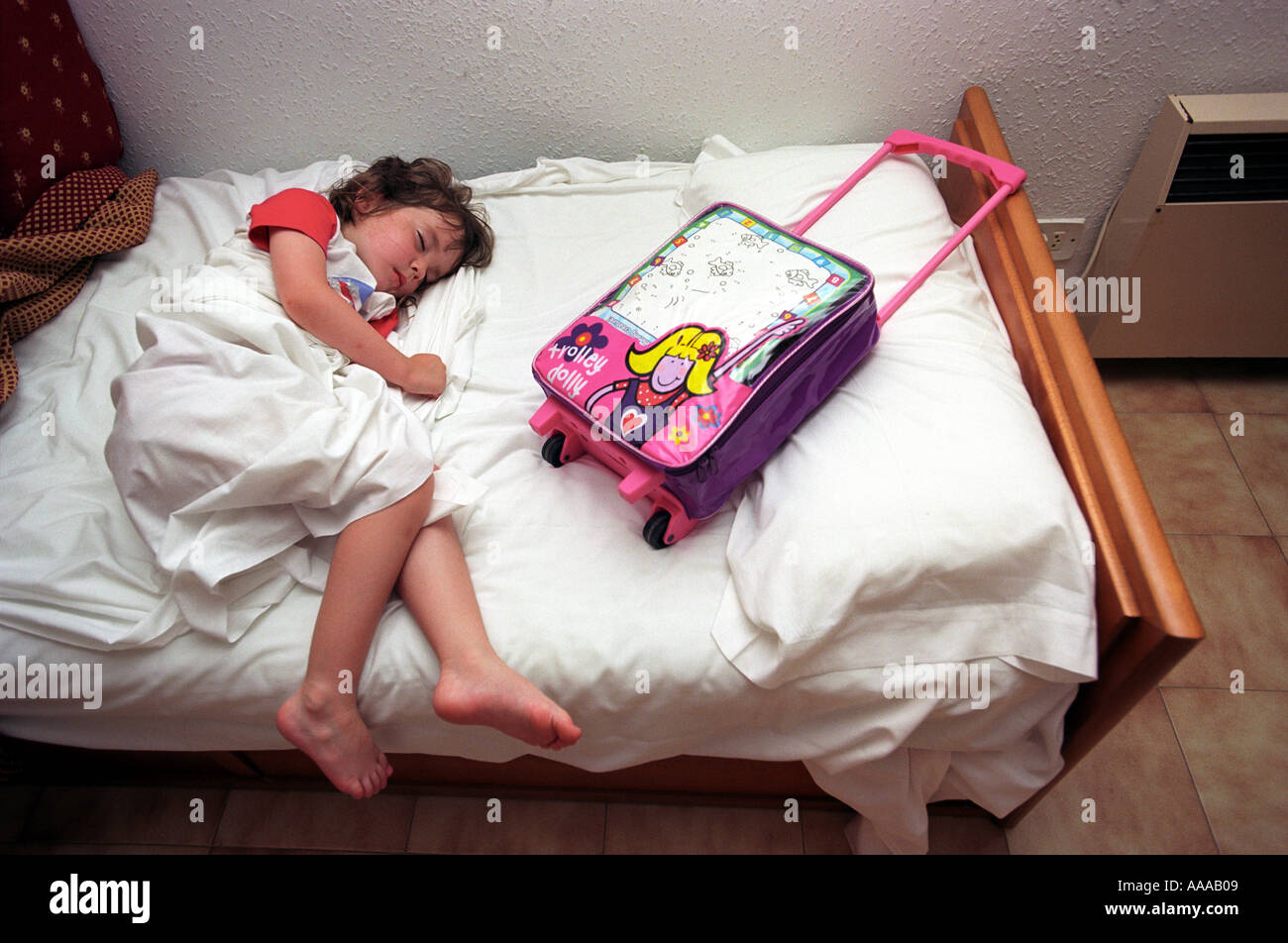 A child asleep with travel bag after a long journey Stock Photo