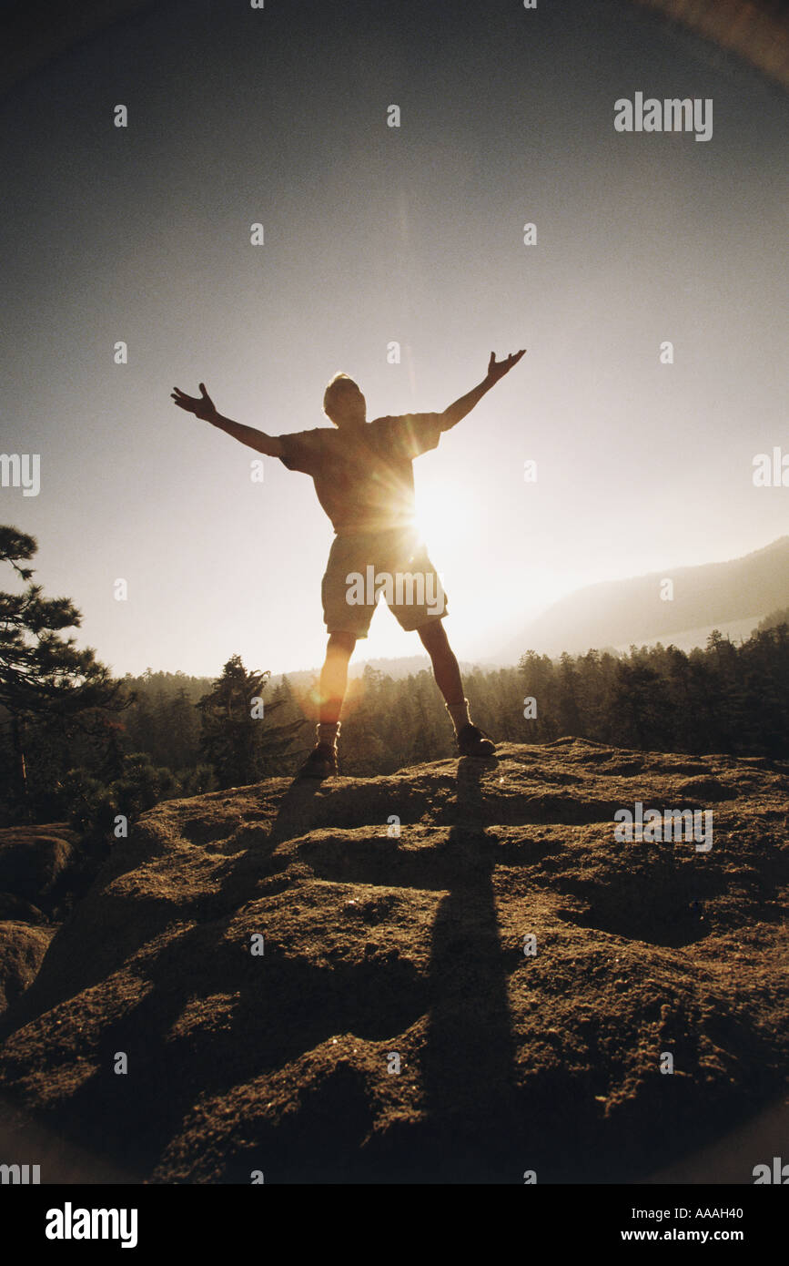 Outstretched Silhouette of a senior man standing outdoors with his arms outstretched ...