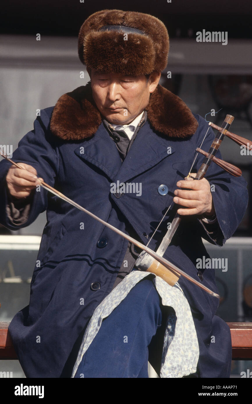 An old man is playing erhu a traditional Chinese musical instrument in a corner of the Temple of Heaven Beijing China Stock Photo
