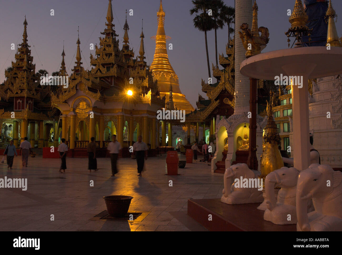 Myanmar Burma Yangon Shwedagon Paya esplanade and stupas with pilgrims at dusk Stock Photo