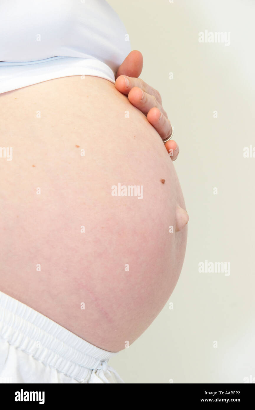 pregnant woman holding her belly Stock Photo - Alamy