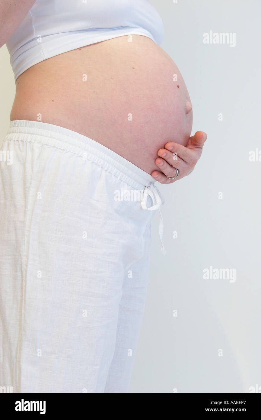 pregnant woman holding her belly Stock Photo - Alamy