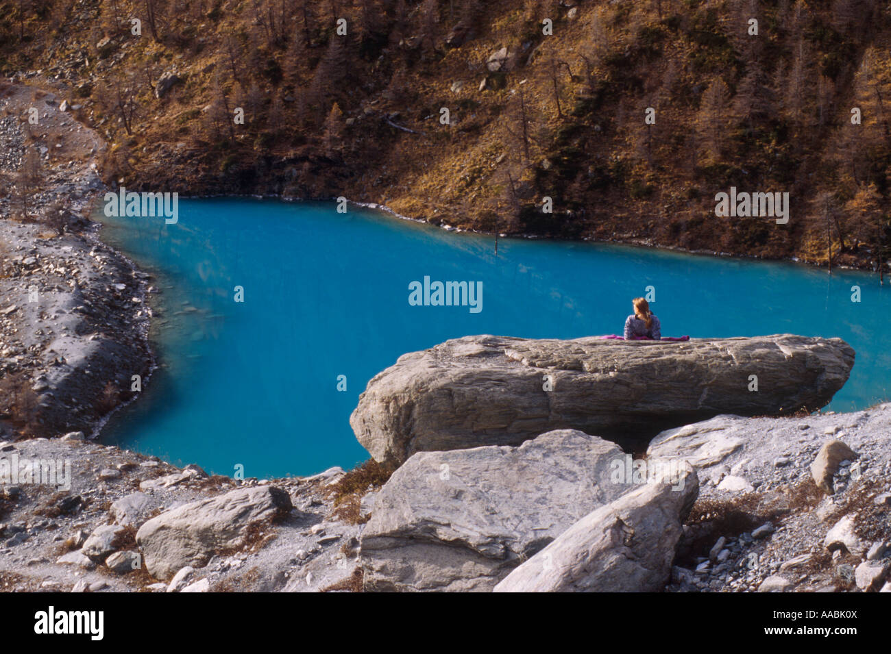 A tourist standing in front of the Blue Lake Ayas Valley Italy Stock Photo