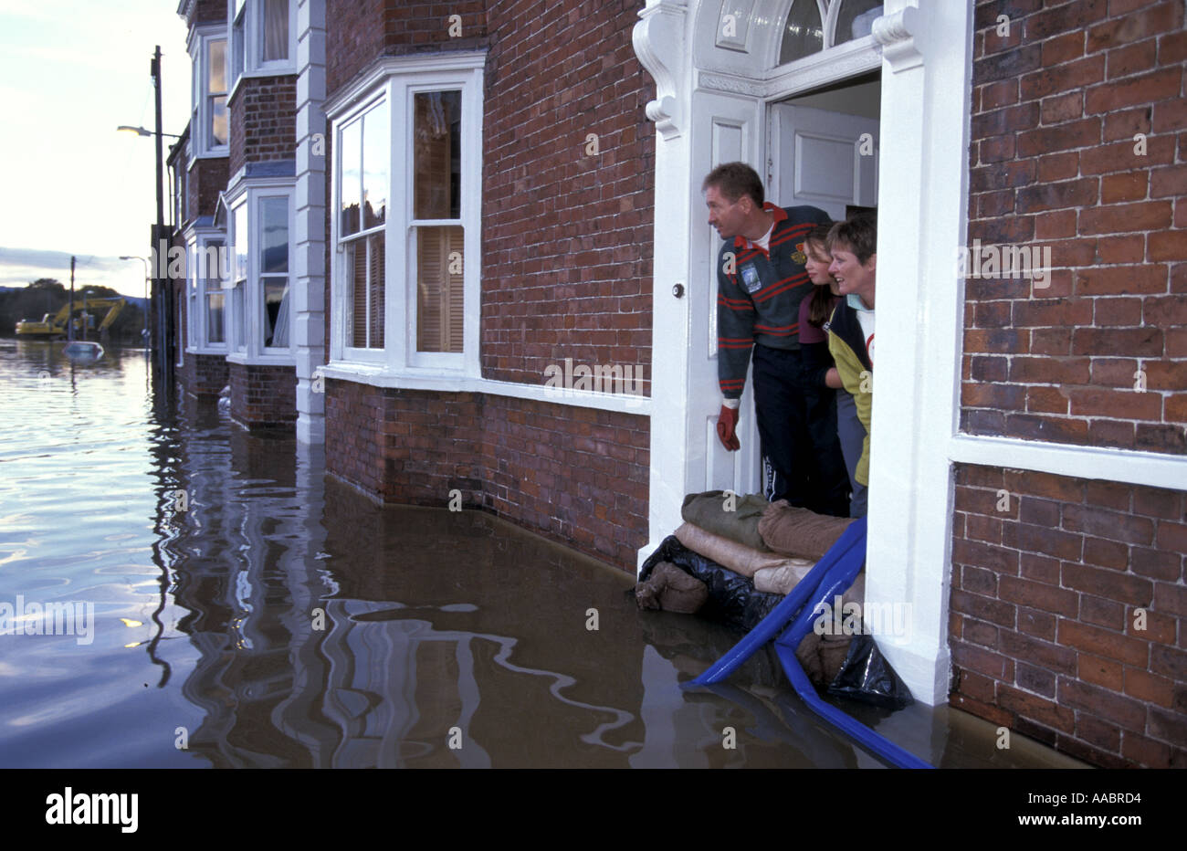 Family in flooded house look out of front door onto flooded street Upton Upon Severn Worcestershire England Stock Photo