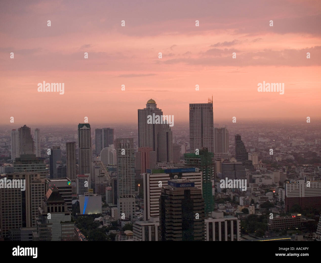 view of Bangkok skyline featuring the dome in State Tower during pink sunset Stock Photo