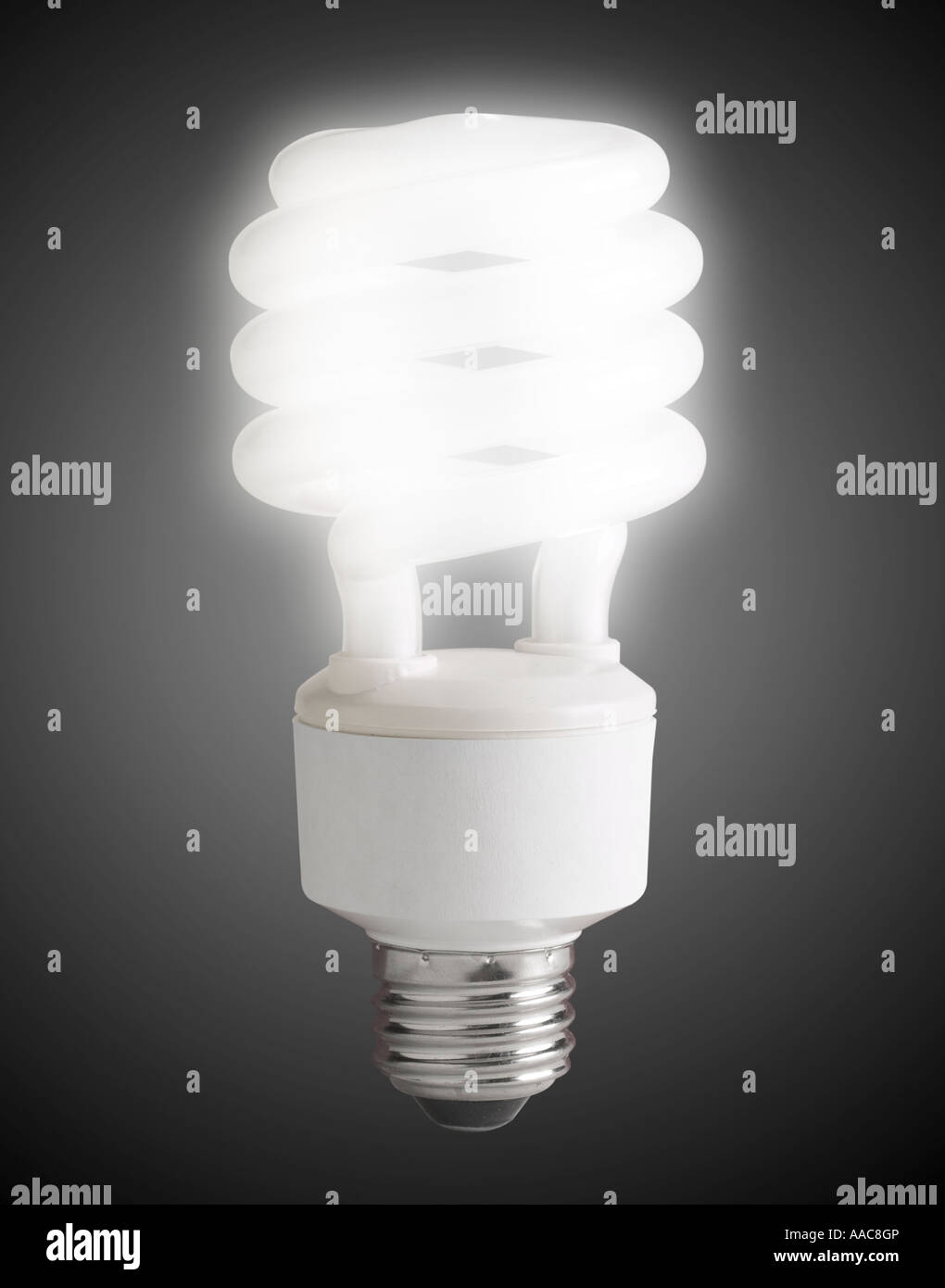 Energy Efficient Compact Fluorescent Light Bulb, CFL Bulb Glowing In Studio Still Life Stock Photo