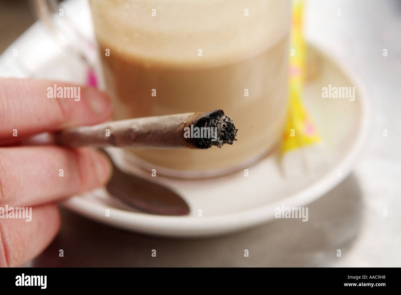 young woman smoking marijuana in a coffee shop in holland, hand close up Stock Photo