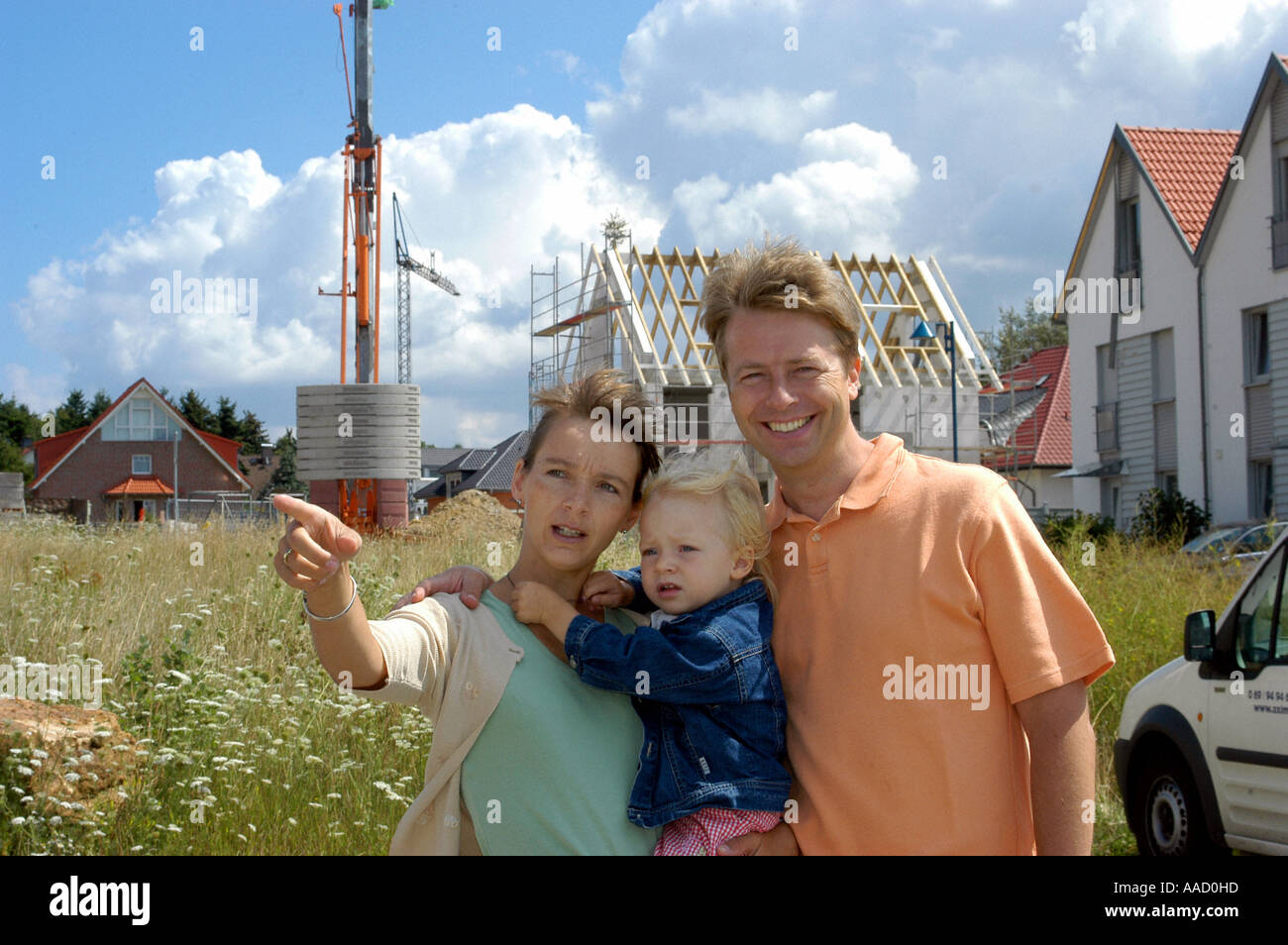young family in front of their own new building Stock Photo - Alamy