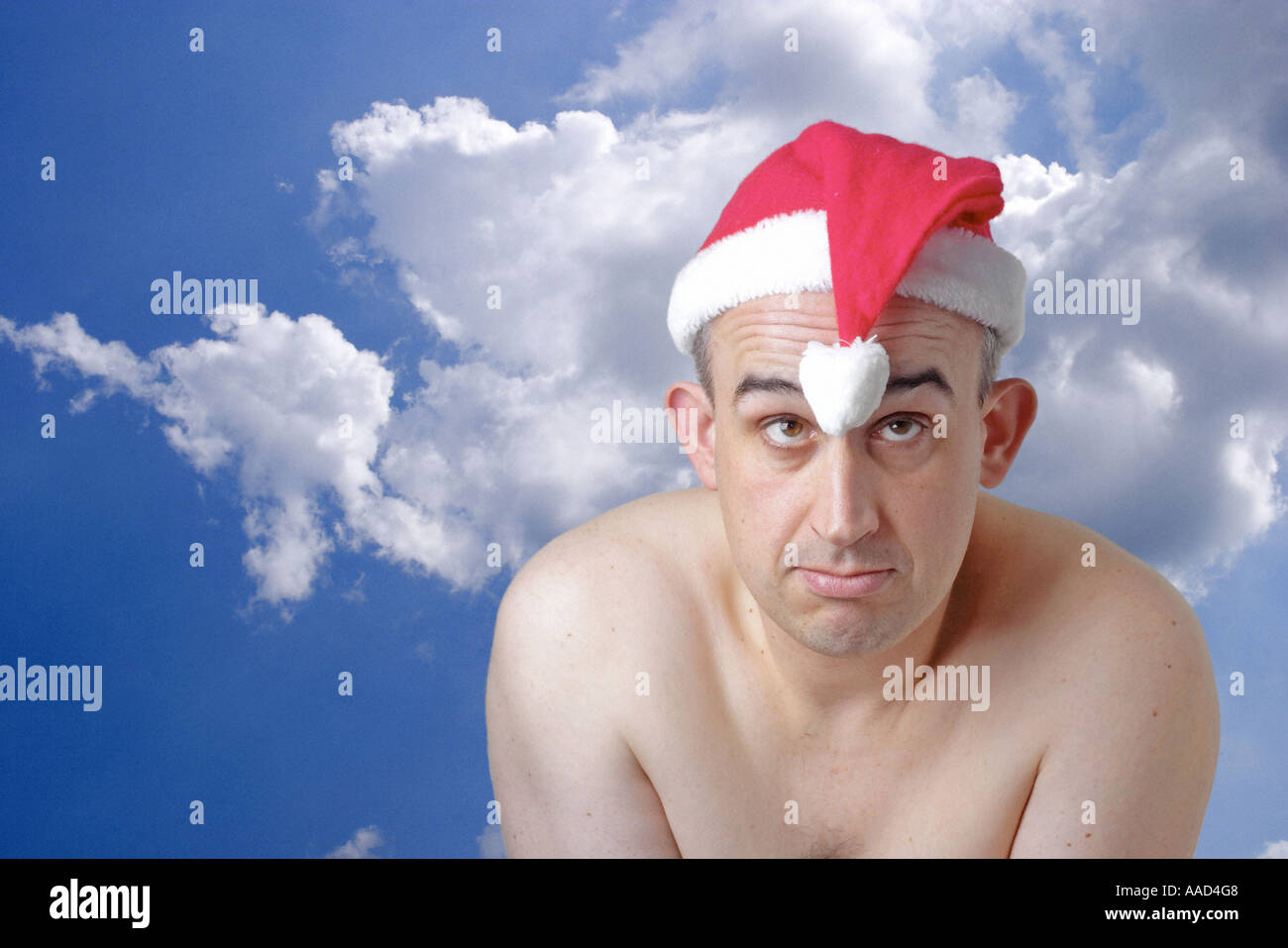 man with a christmas cap infront of clouded sky Stock Photo