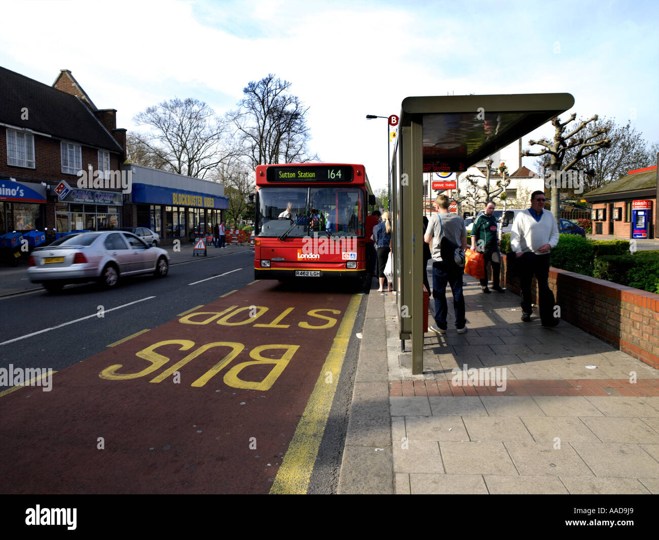 Dominos Pizza and Bus at Bus Stop with Passengers in Sutton Surrey England Stock Photo