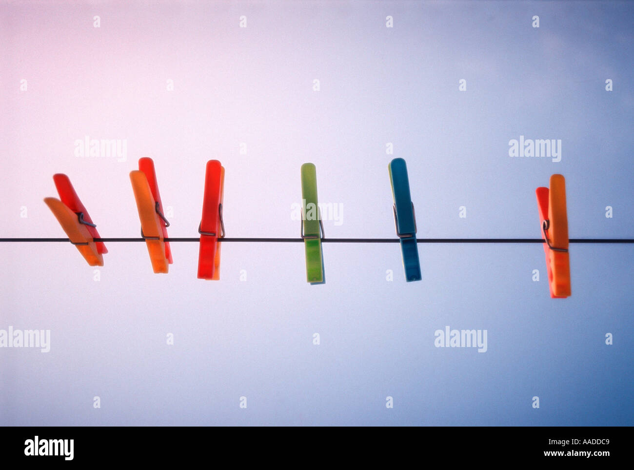Coloured clothes pegs on a washing line Stock Photo