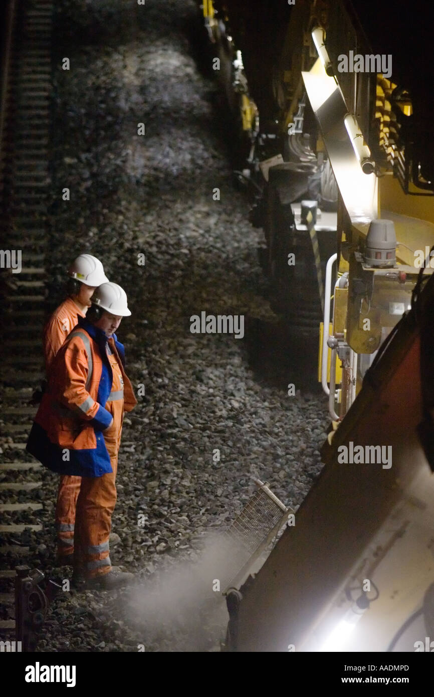 Railway workers supervising ballast cleaning machine Stock Photo Alamy