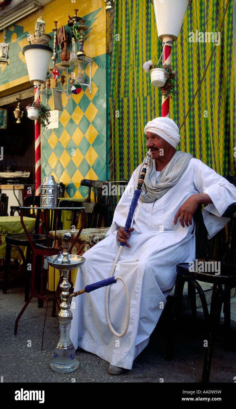 Egyptian man smoking a sheesha at a streetside cafe in Luxor Stock Photo