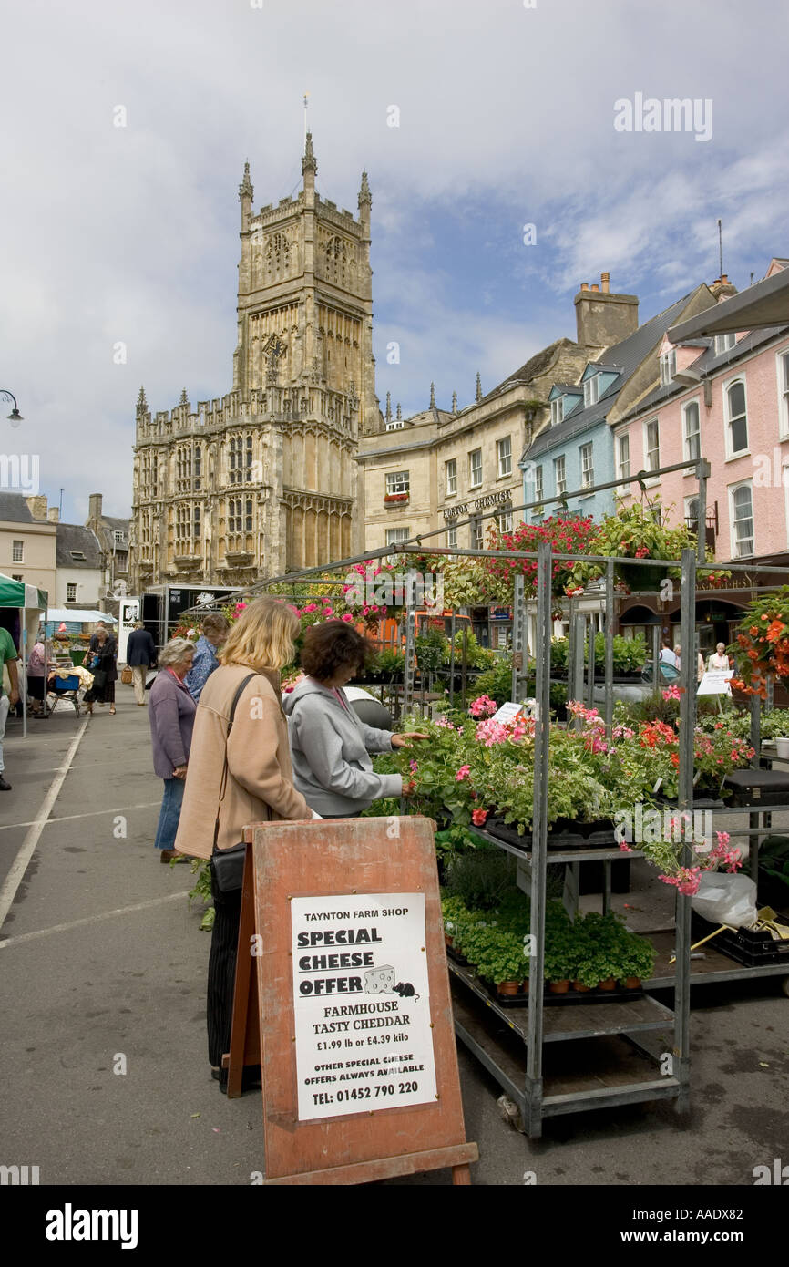 Market day in the market square of Cirencester with 15th century Church of St John in the background UK Stock Photo