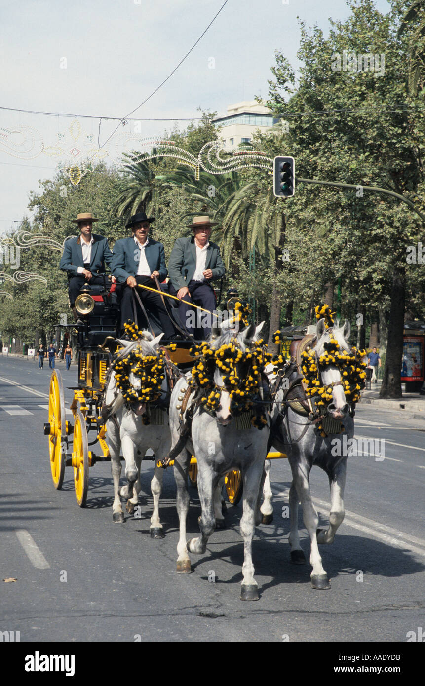 Three coach drivers on their four horse coach at the Malaga feria Andalucia Spain Stock Photo