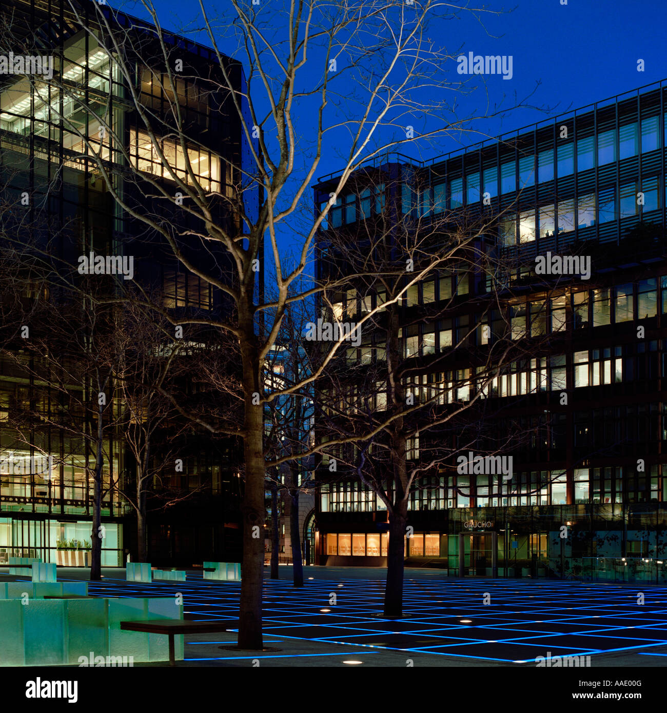 dusk shot of Broadgate, London; inc. office blocks, blue pavement lighting, trees Stock Photo