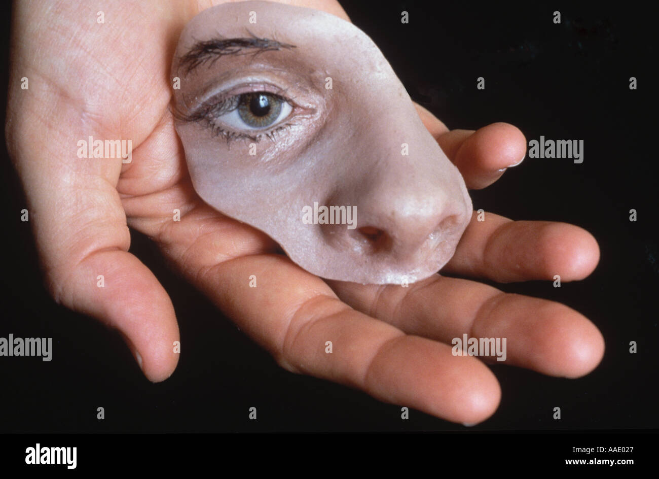 A hand holds a section of molded face used as a replacement for facial cancer surgery Stock Photo
