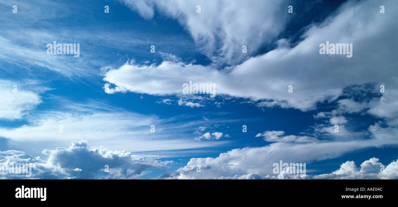 White puffy clouds against a deep blue sky Stock Photo