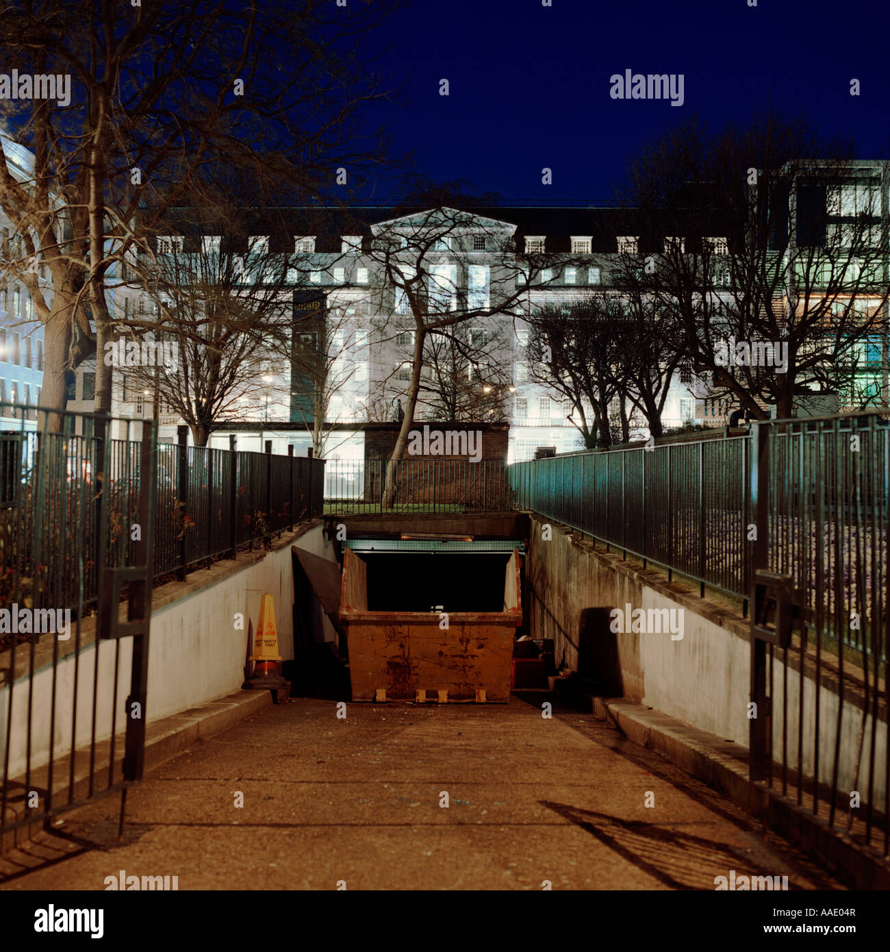 dusk shot of neo-classical façade office block in Finsbury Square, London; inc. trees, ramp, skip/dumpster Stock Photo
