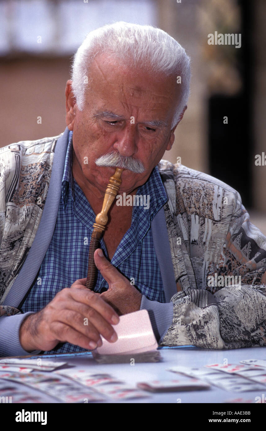 Lebanese man smoking nargileh pipe and playing cards Sidon southern