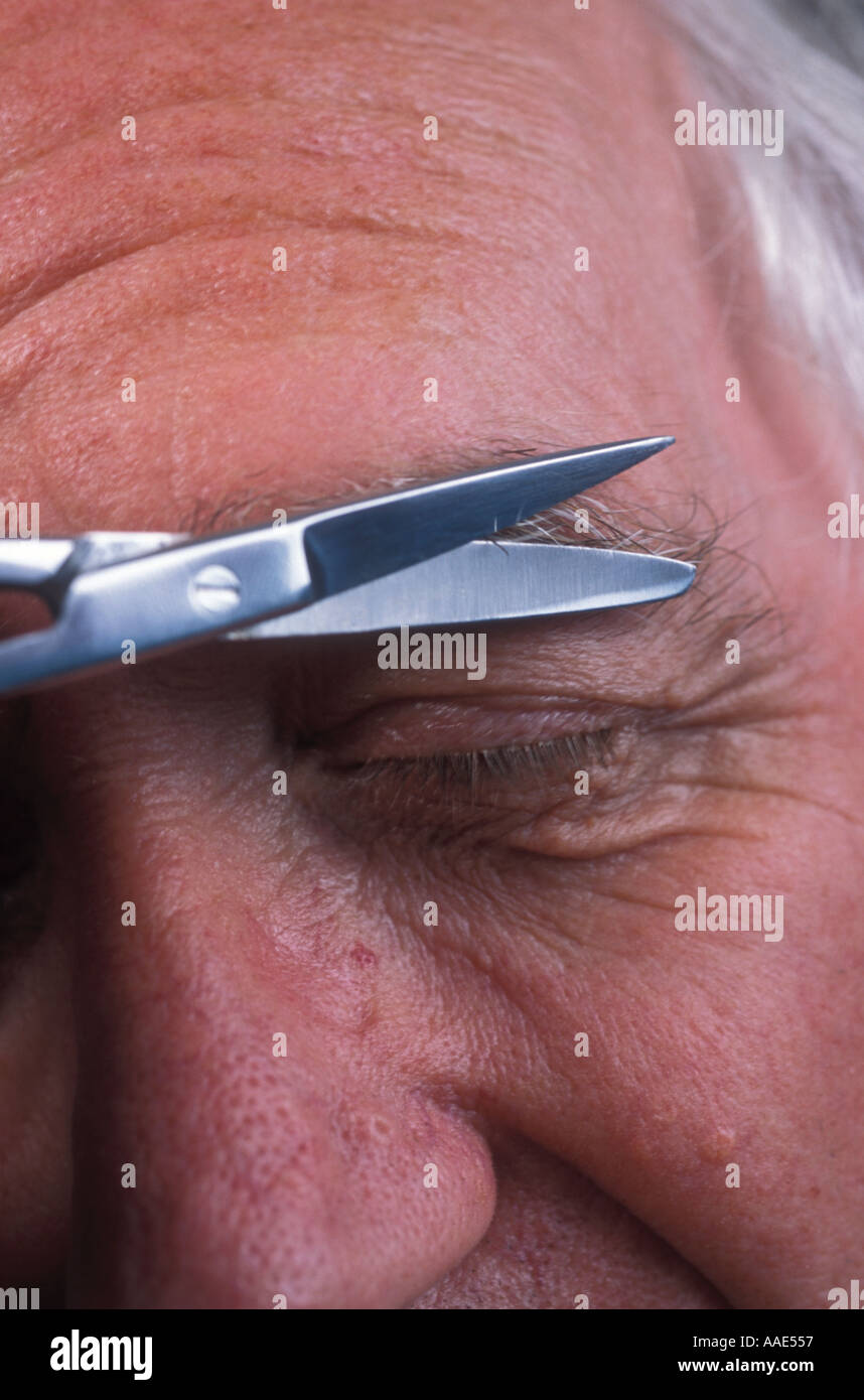 Senior man trimming eyebrow with scissors Stock Photo Alamy