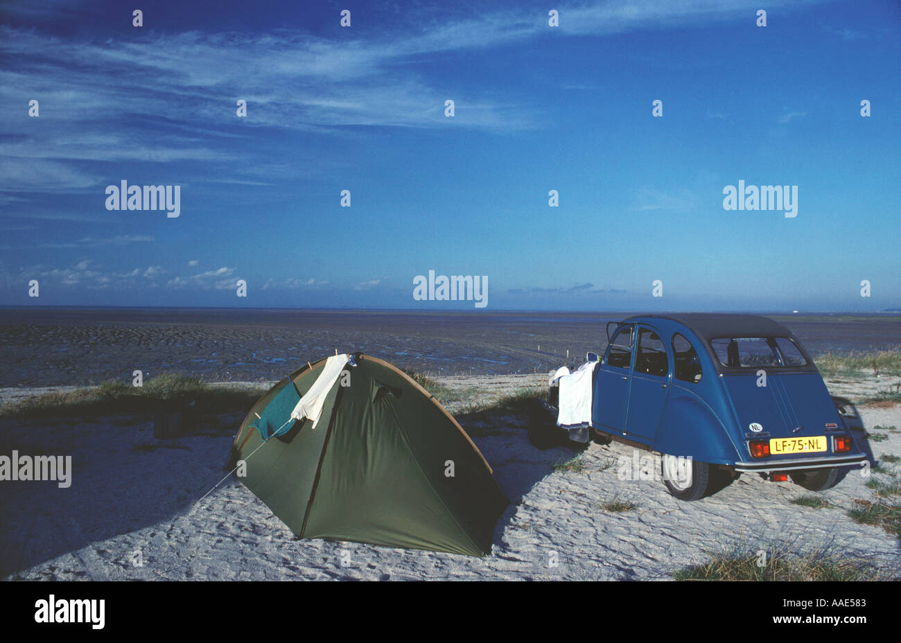 Small green tent and blue Citroen 2cv car on a camping at the coast at low  tide in Normandy France Stock Photo - Alamy