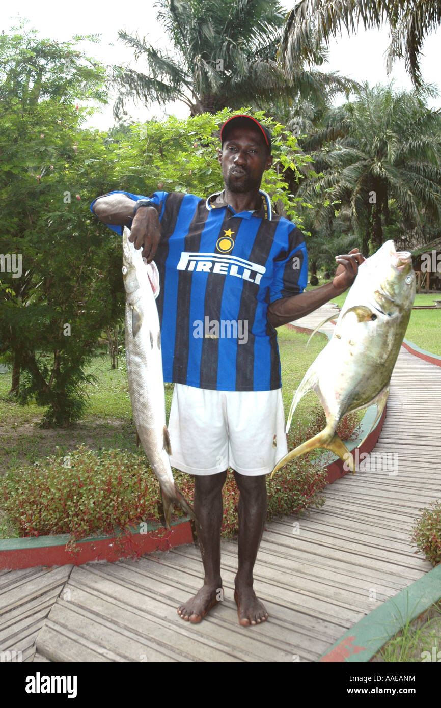 A Loango Lodge boatman shows off a client's afternoon catch in the lagoon--two fish of impressive size Stock Photo