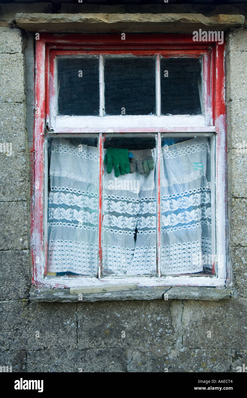 Window with woollen gloves and net curtain Thwaite village Swaledale Yorkshire Dales UK Stock Photo