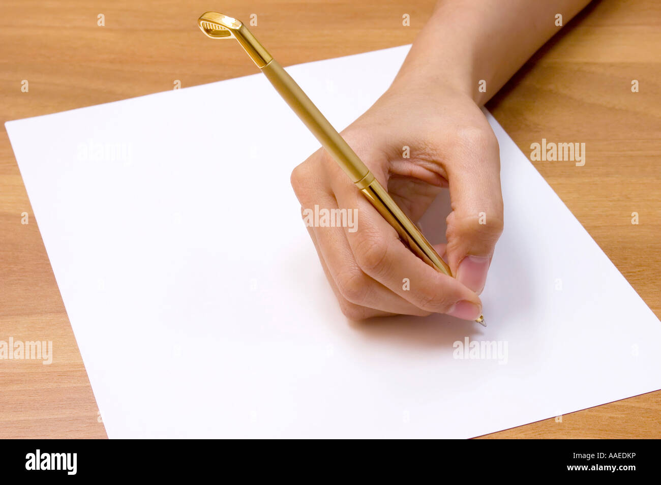 Female hand holding a golf club shaped pen and a blank paper Stock ...