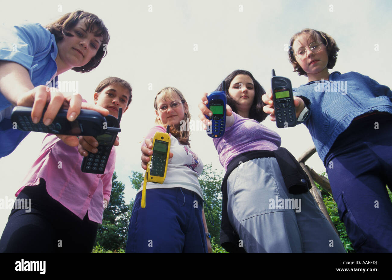 low angle view of group of teenage girls with variety of mobile phones Stock Photo