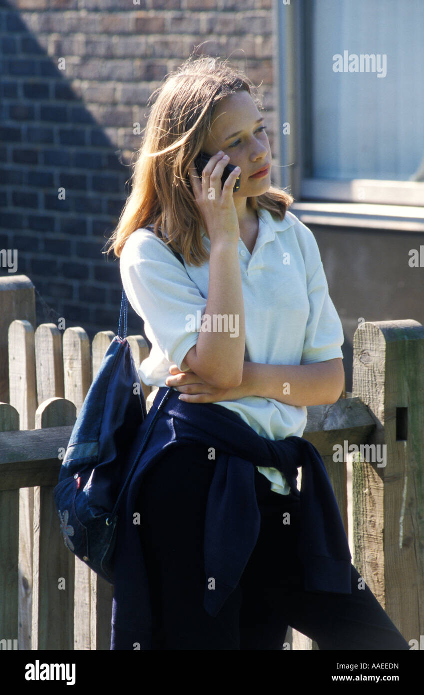 blonde teenage secondary schoolgirl in uniform talking on her mobile ...