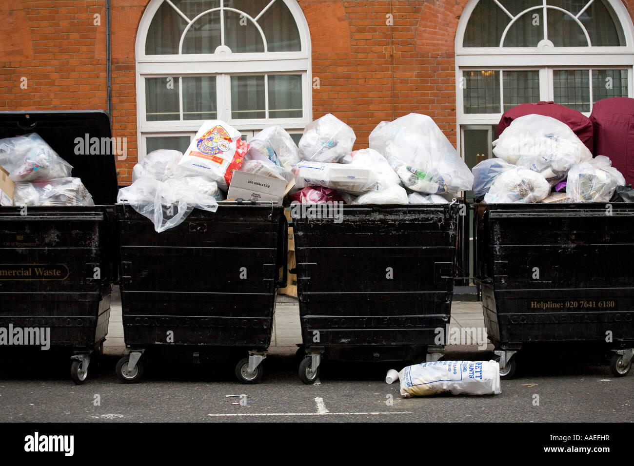 Wheelie bins overflowing with rubbish Stock Photo