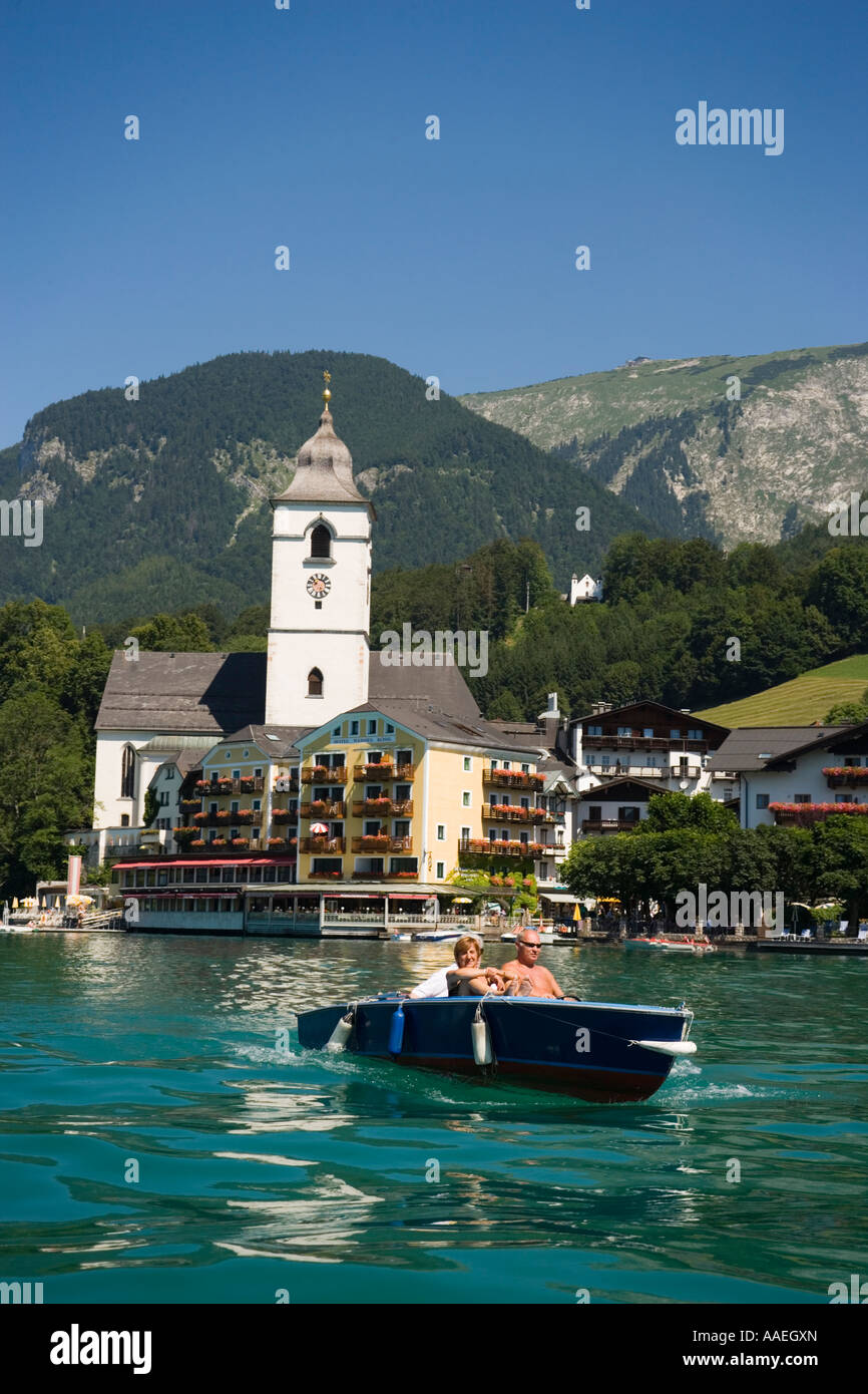 Wolfgangsee Hotel Im Weissen Rossel am Wolfgangsee people in an electric boat passing St Wolfgang Upper Austria Salzkammergut Stock Photo